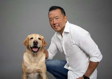 Michael Shikashio with a Labrador